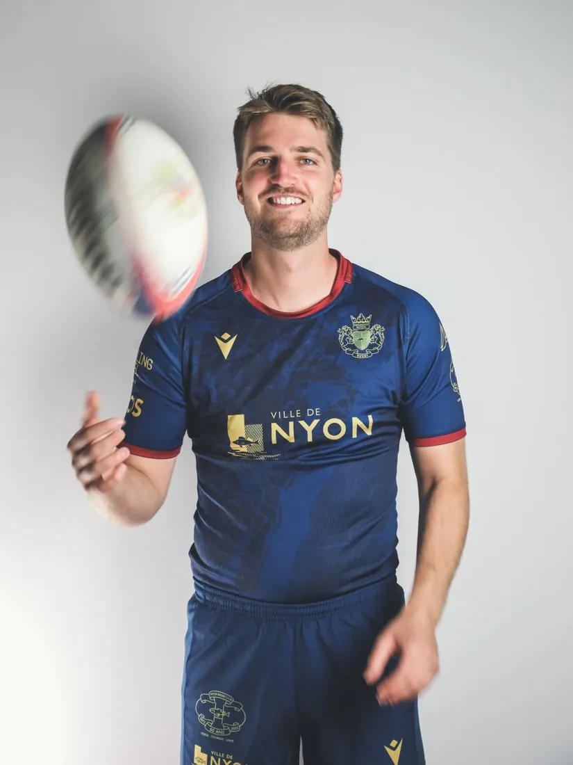 Joueur en maillot bleu nuit lançant un ballon, à la séance photo
