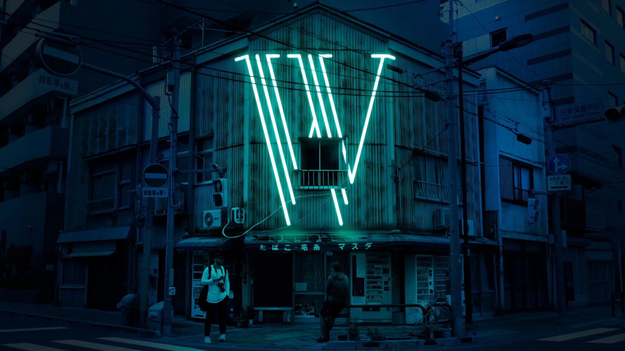 Lettre W en néon turquoise sur une façade à un coin de rue, Tokyo
